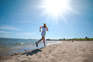 Sport woman running on beach