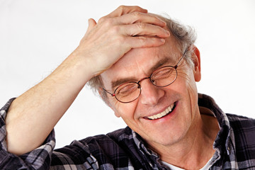 man slapping hand on his head, laughing