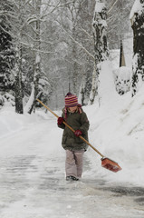 Kleines Mädchen fegt Schnee
