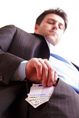 Manager steckt Geld in Hosentasche