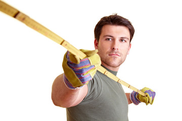 Handwerker misst mit Metermaß