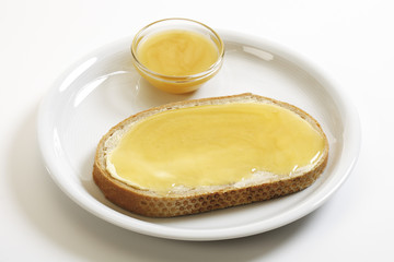 Honigbrot auf Teller mit Honigschale