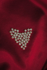 pearls heart on an elegant red silk