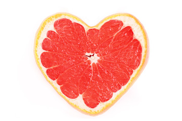 Close up of sliced pink grapefruit in the form of heart isolated