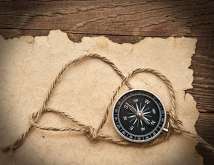 compass, rope and old paper on border wood background