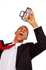 A businessman looks for the last drop of coffee in his his mug.