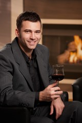 Businessman drinking wine at home