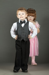 The little boy. The little girl costs behind with a flower