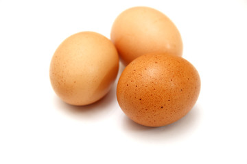 Three eggs lying down on a white linen background