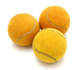 Three old tennis balls on a white background
