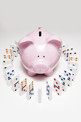 Piggy bank surrounded by dominos