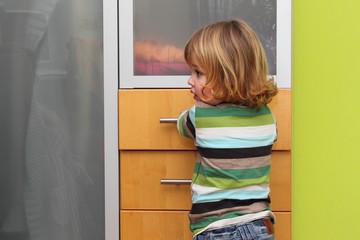 Kleiner junge am Kleiderschrank