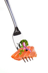 Delicious salmon piece on fork against white background.