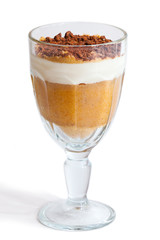 Dessert with bananas and cream in a glass isolated on white