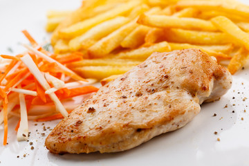 Grilled meat, French fries and vegetables