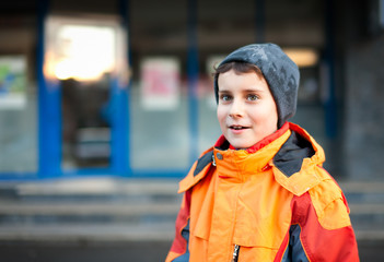 Boy in orange coat in urban environment