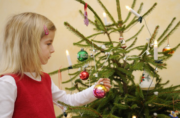Mädchen schmückt Weihnachtsbaum
