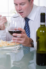 man with glass of red wine at restaurant