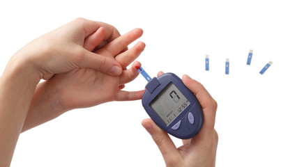 Woman checks glucose level in blood at the child