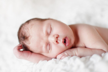 Fototapeta na wymiar Newborn baby sleeping. Soft focus, shallow DoF.