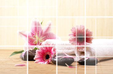 A spa composition of lily flowers, lava stones and a white towel