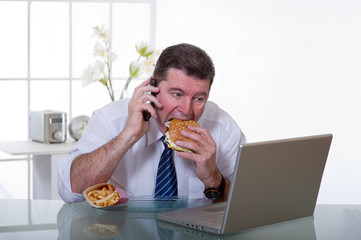 man at office with phone eat unhealthy food