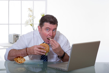 man at office working and eat unhealthy fast food