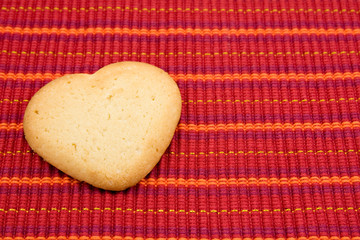 heart shaped cookie on red striped tablecloth