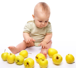 Little boy play with apples