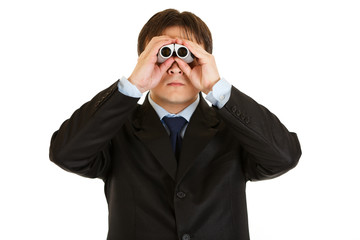 Serious young businessman looking through binoculars