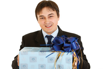 Smiling young businessman holding present in hands