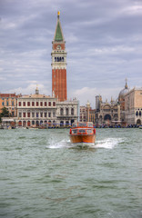 Fototapeta premium Waater taxi crossing Venice Lagoon in Italy with San Marco Piaz
