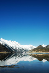 Naklejka na ściany i meble Landscape of snow mountains and lake
