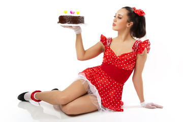 The young woman poses on the floor in a red dress.