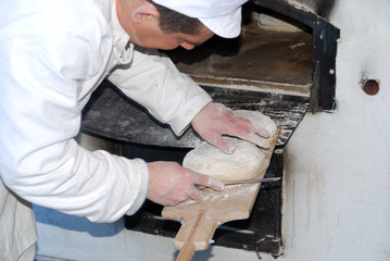 Baker cutting a round loaf