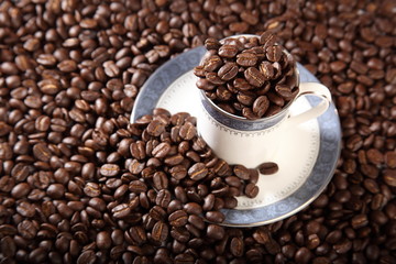 Cup and saucer full of roasted coffee beans