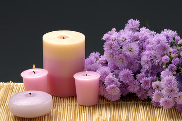 Obraz na płótnie Canvas beauty treatment- candles and daisy flowers on black