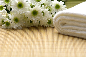 Obraz na płótnie Canvas White towels and nice marigolds on mat
