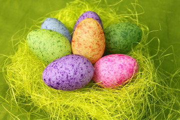 Osternest auf grünem Grund mit bunten Eiern