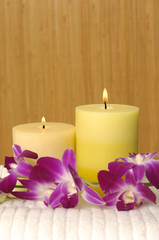 Spa with candle and orchid on white towel