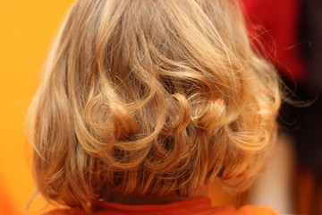 Kleiner Junge mit langen Haaren von hinten