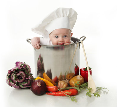 Naklejki Licking baby sitting in a chef's pot