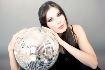 Beautiful young woman holding disco ball