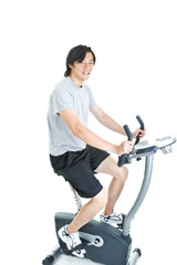 Fototapeta premium Asian Man Riding Stationary Exercise Bike, Isolated On White Bac