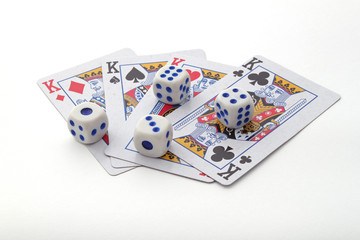 Gambling with playing cards and dice over a white background.