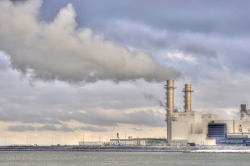 Power station with dramatically clouded and smoky sky