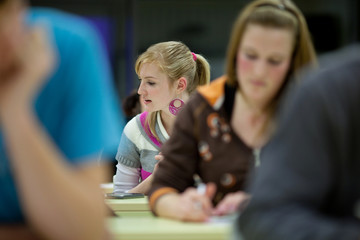 pretty female college student sitting in a classroom