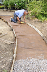Man building gravel path with wood edging