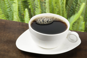 Taza blanca  con café tinto   en Fondo verde