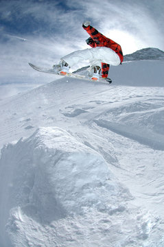 Jumping snowboarder in the mountains
